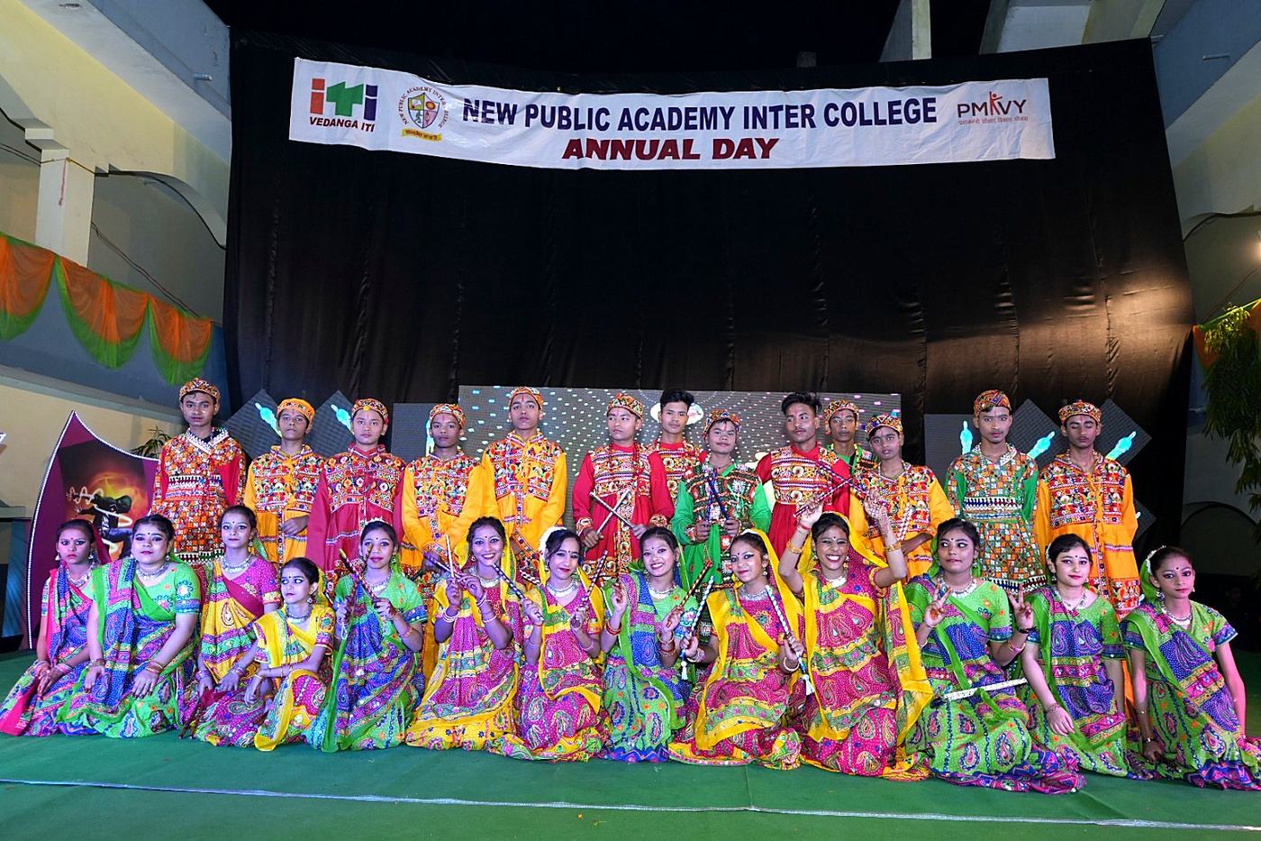 Students in bright folk costumes posed on stage