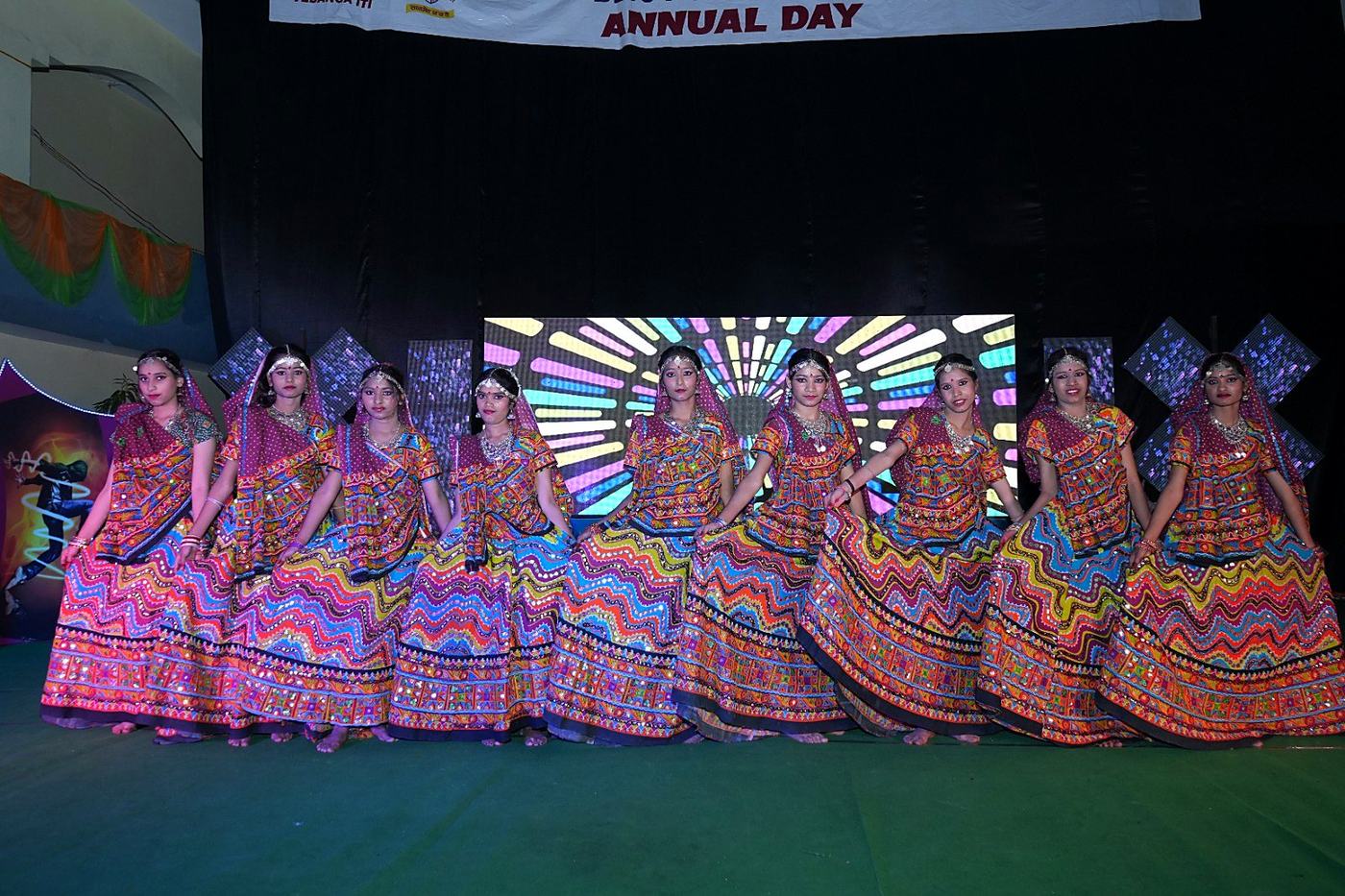 Students in colourful traditional dress dancing on the Annual Day stage