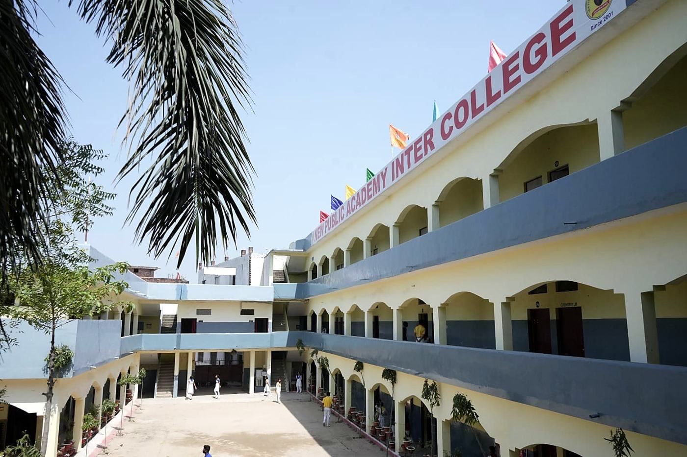 Courtyard surrounded by three floors of classrooms under a clear sky